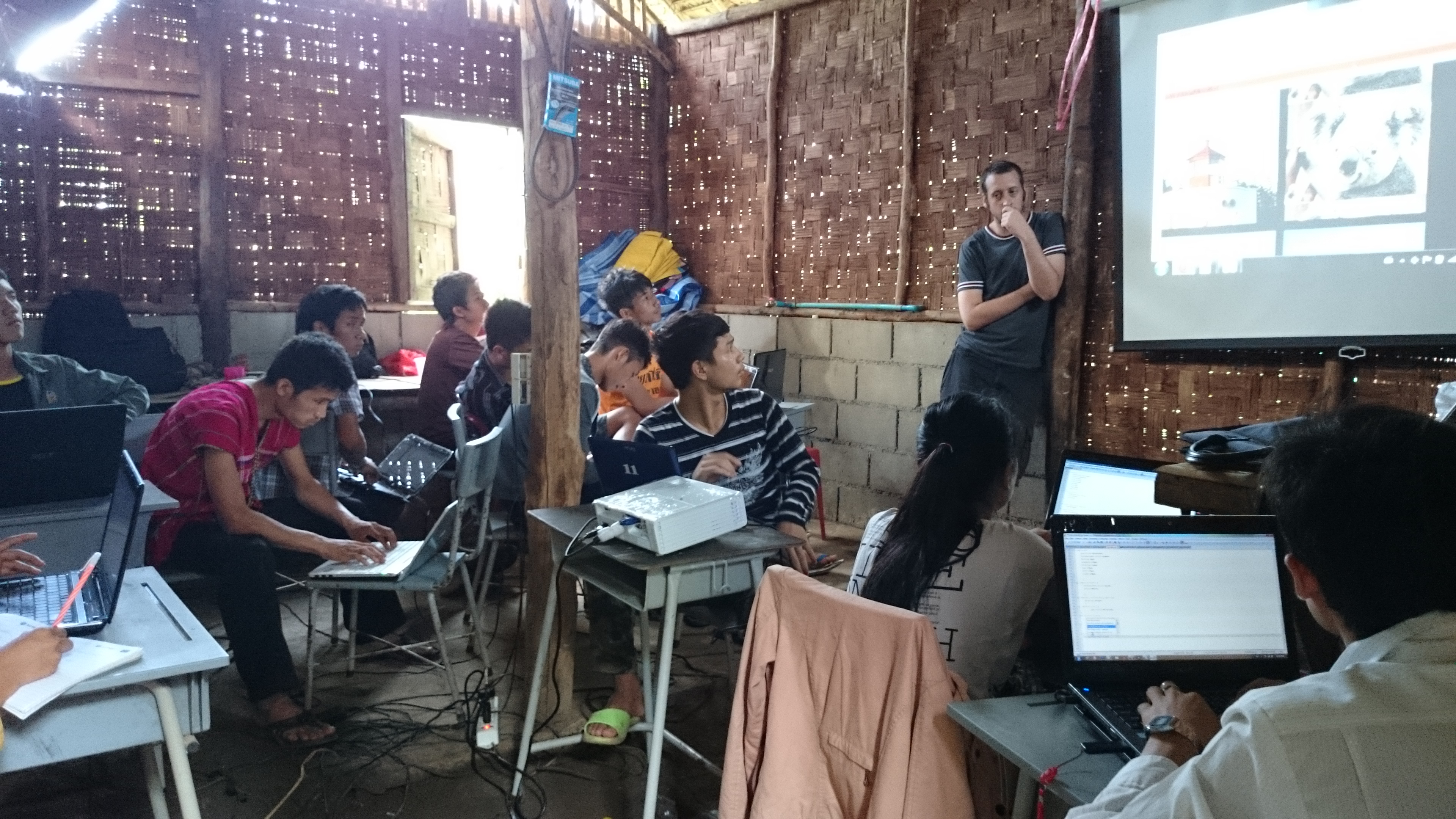 Pierre and his Karen refugee students focusing on their code